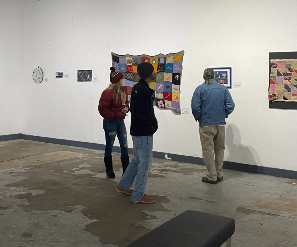 people looking at art on white walls